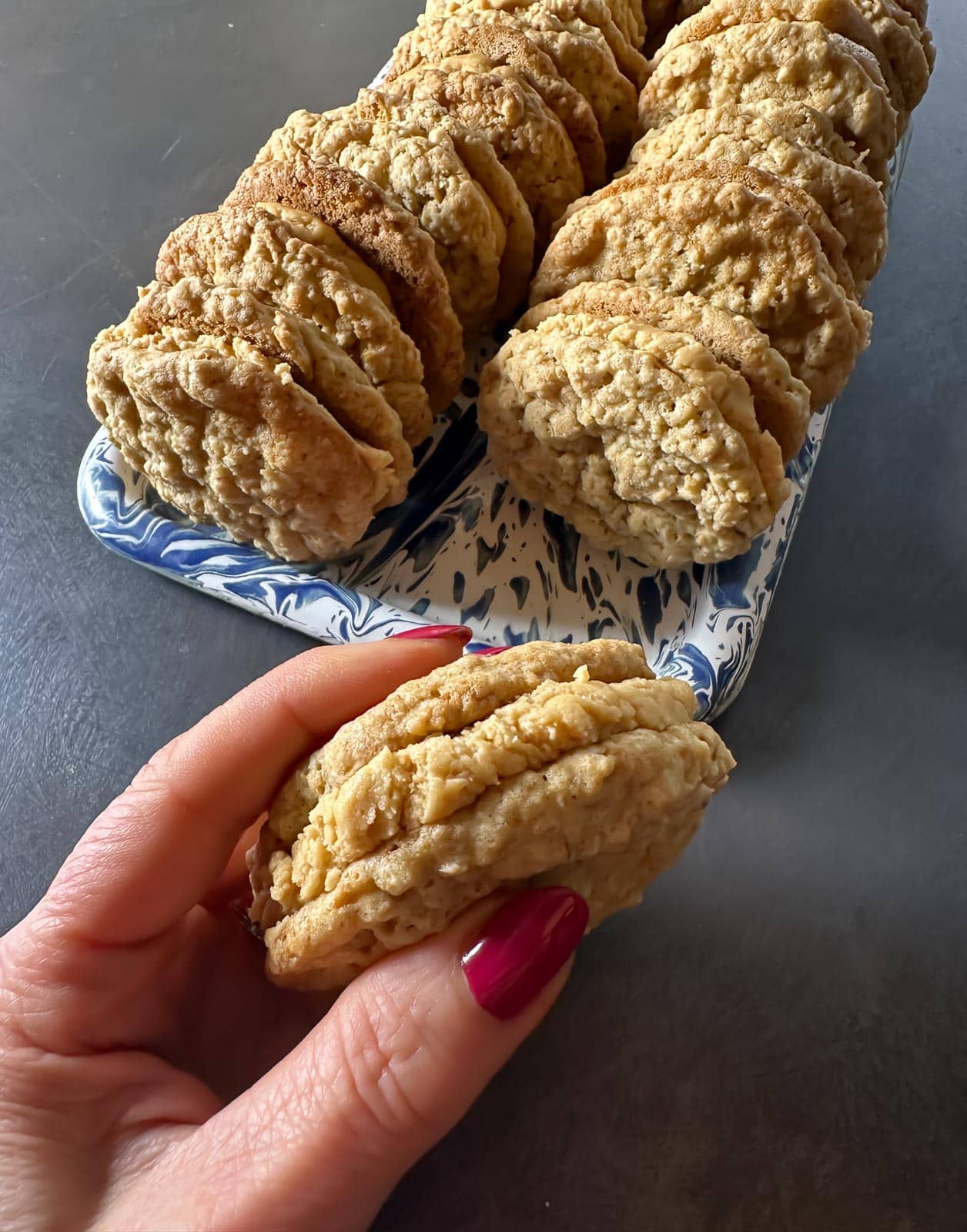 Low FODMAP Girl Scout Do-Si-Do Copycat cookies on tray and held in hand.