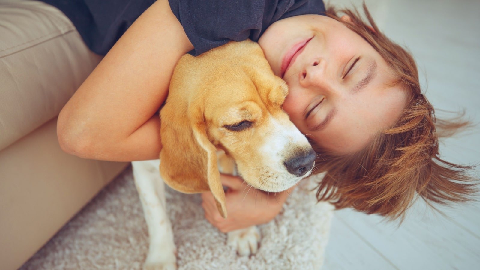 Boy hugging beagle. 