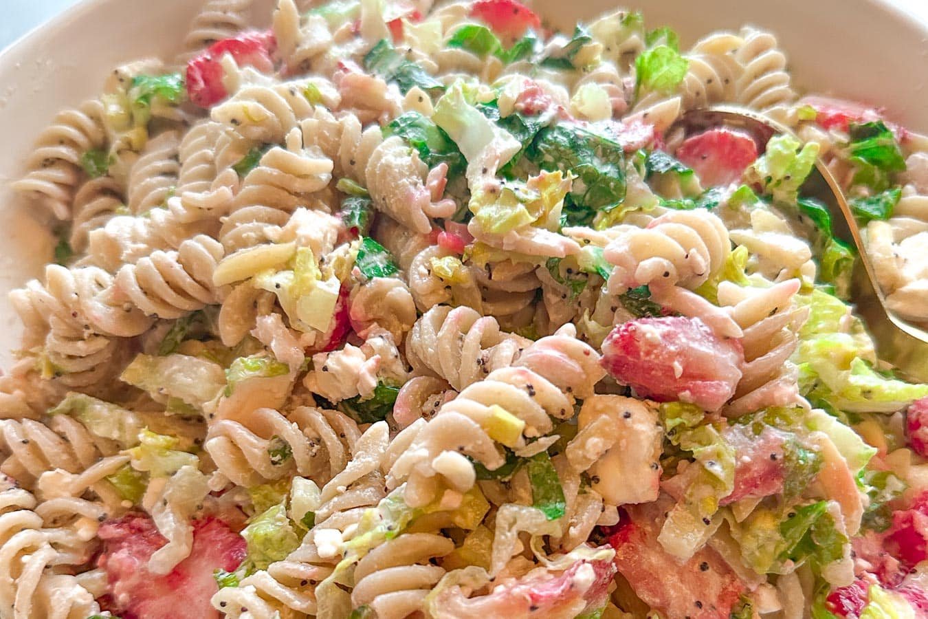 strawberry feta pasta salad in white bowl horizontal image.