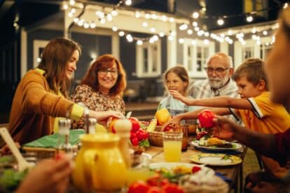 Group of Multiethnic Diverse People Having Fun, Communicating with Each Other and Eating at Outdoors Dinner. Family and Friends Gathered Outside Their Home on a Warm Summer Evening.