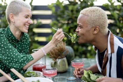 Concept of relationship and enjoying time together. Blonde short-haired couple at table with organic food. Healthy eating
