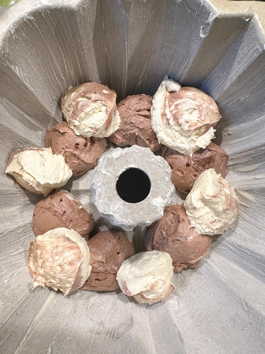 alternating dollops of batter in Bundt Pan for Marble cake.