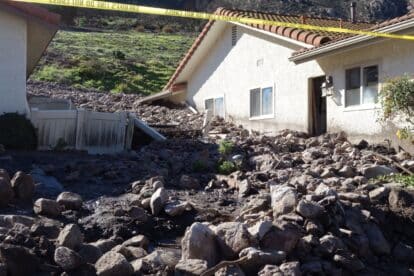 Many homes destroyed by a mudslide with mud debris and boulders