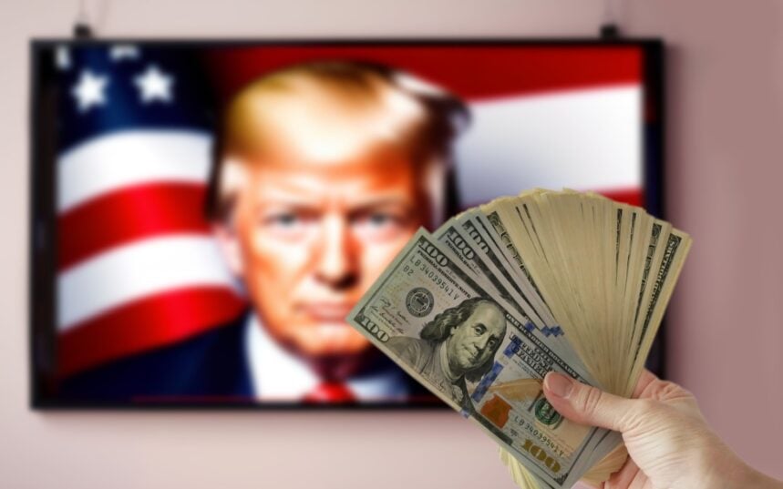 Washington, USA - September 16 2024: hand holding pile of money cash on Donald Trump portrait on TV background. US election 2024.