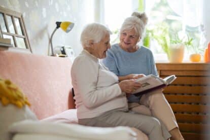 Senior woman and her adult daughter looking at photo album together
