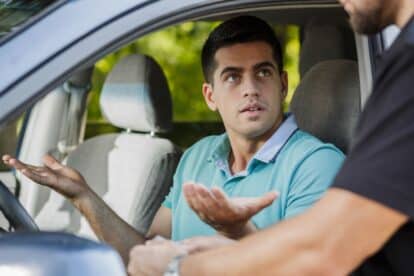 Confused young man in the car stopped by policeman
