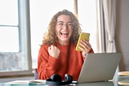 Young happy lucky woman student feeling excited winner holding cellphone using mobile phone winning online, receiving great news or sms offer on smartphone, getting new job celebrating success.