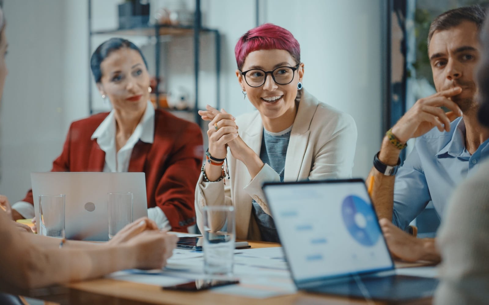 Office Meeting in Conference Room: Beautiful Specialist with Short Pink Hair Talks about Firm Strategy with Diverse Team of Professional Businesspeople. Creative Start-up Team Discusses Big Project