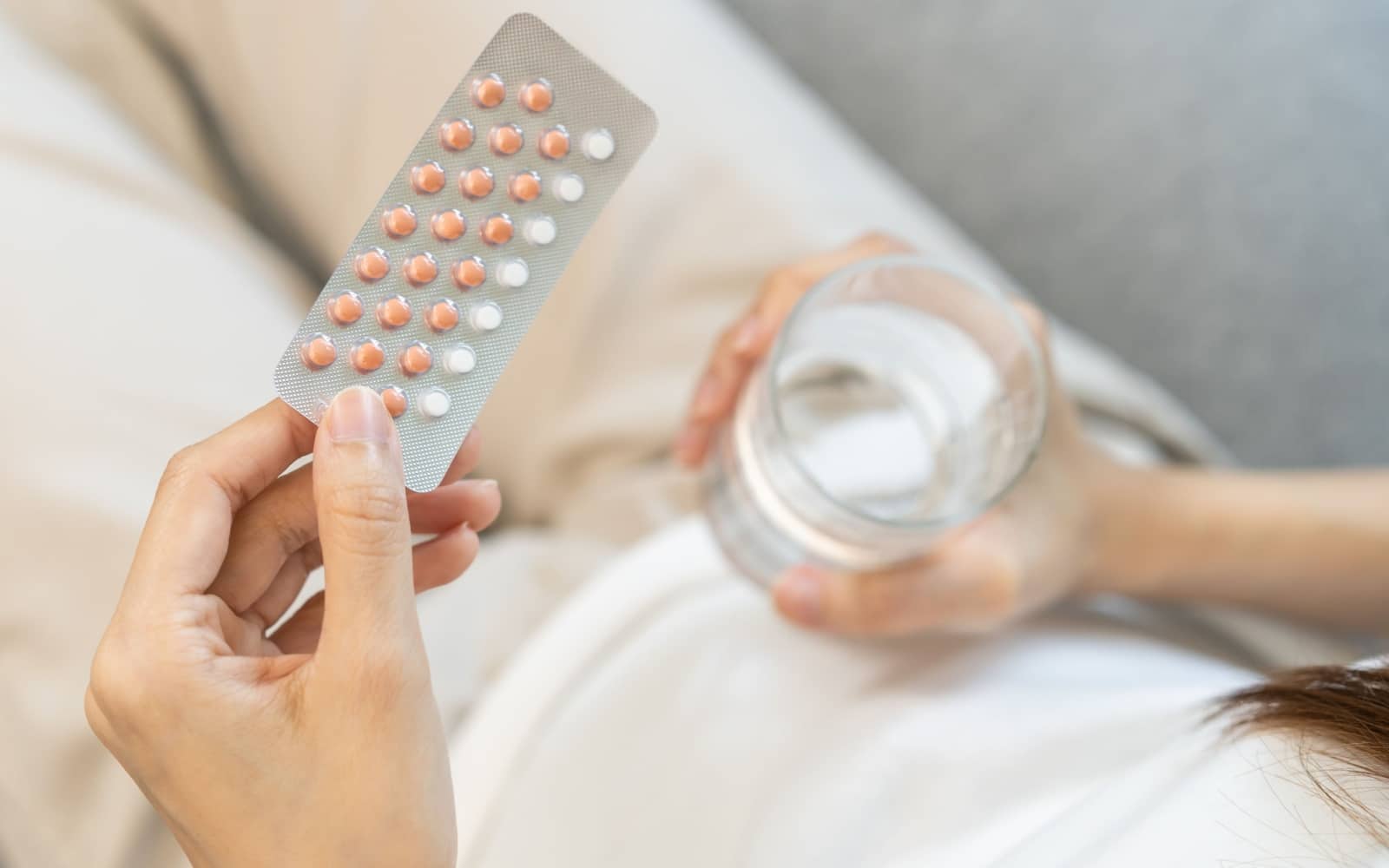 Contraception and pregnancy, menstruation concept, birth control pills asian young woman hand holding hormonal oral contraceptive medicine, take pharmaceutical to prevention, safe virus sex disease.