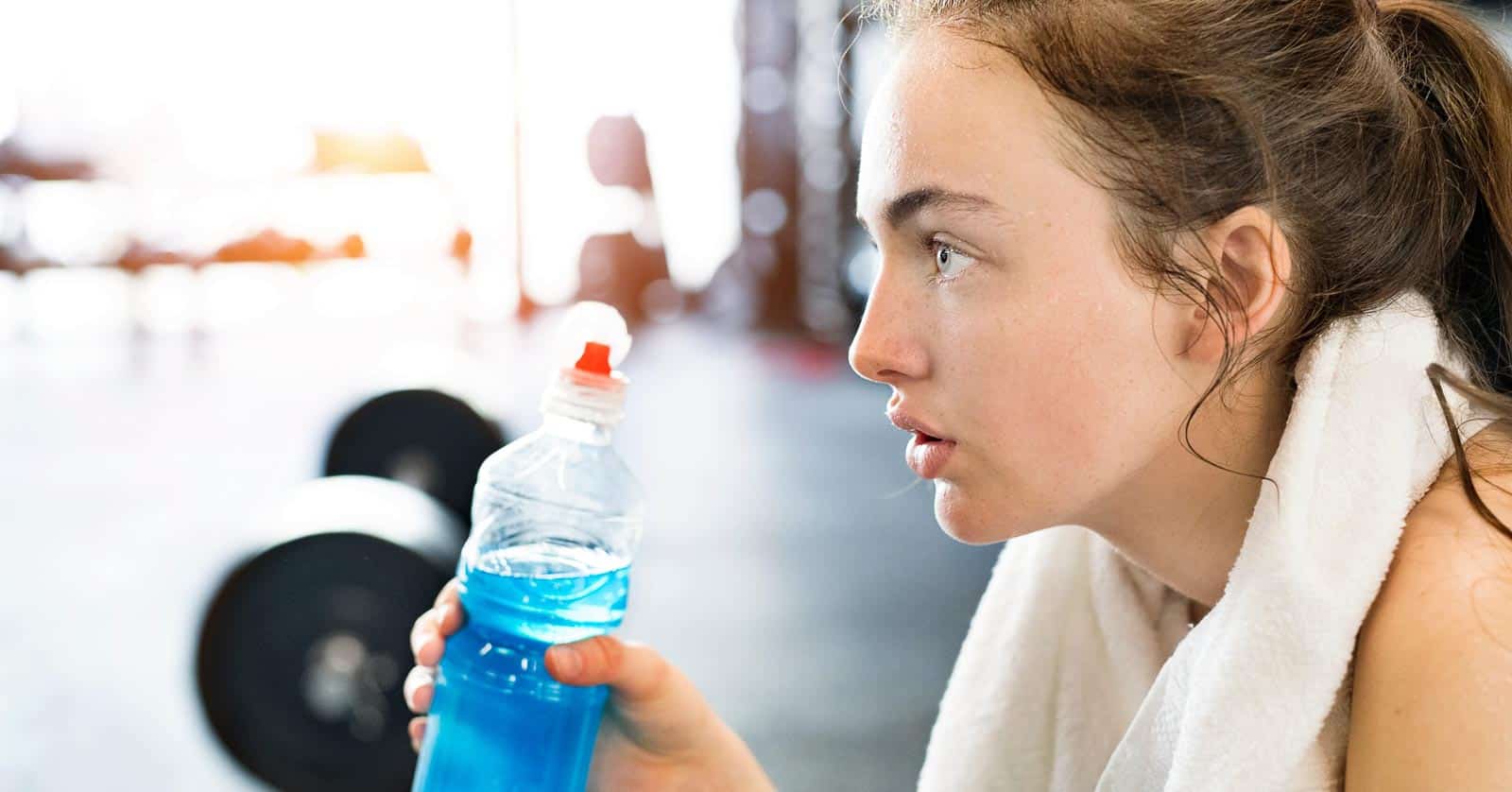 woman in gym. blue energy drink. electrolytes. halfpoint via 123rf