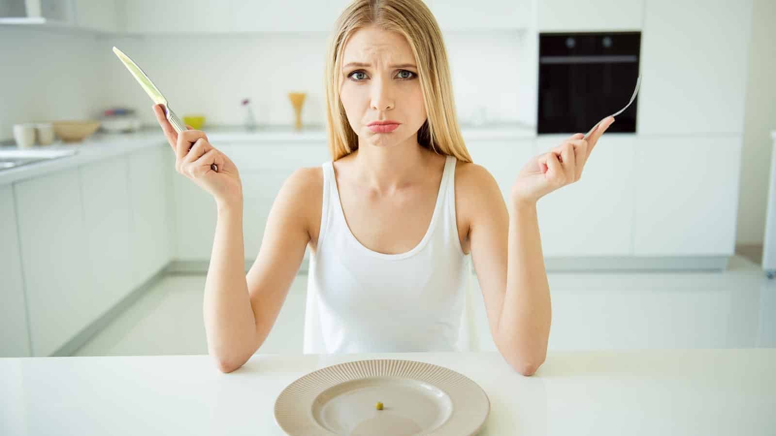 woman looking at almost empty plate. deagreez via 123rf.