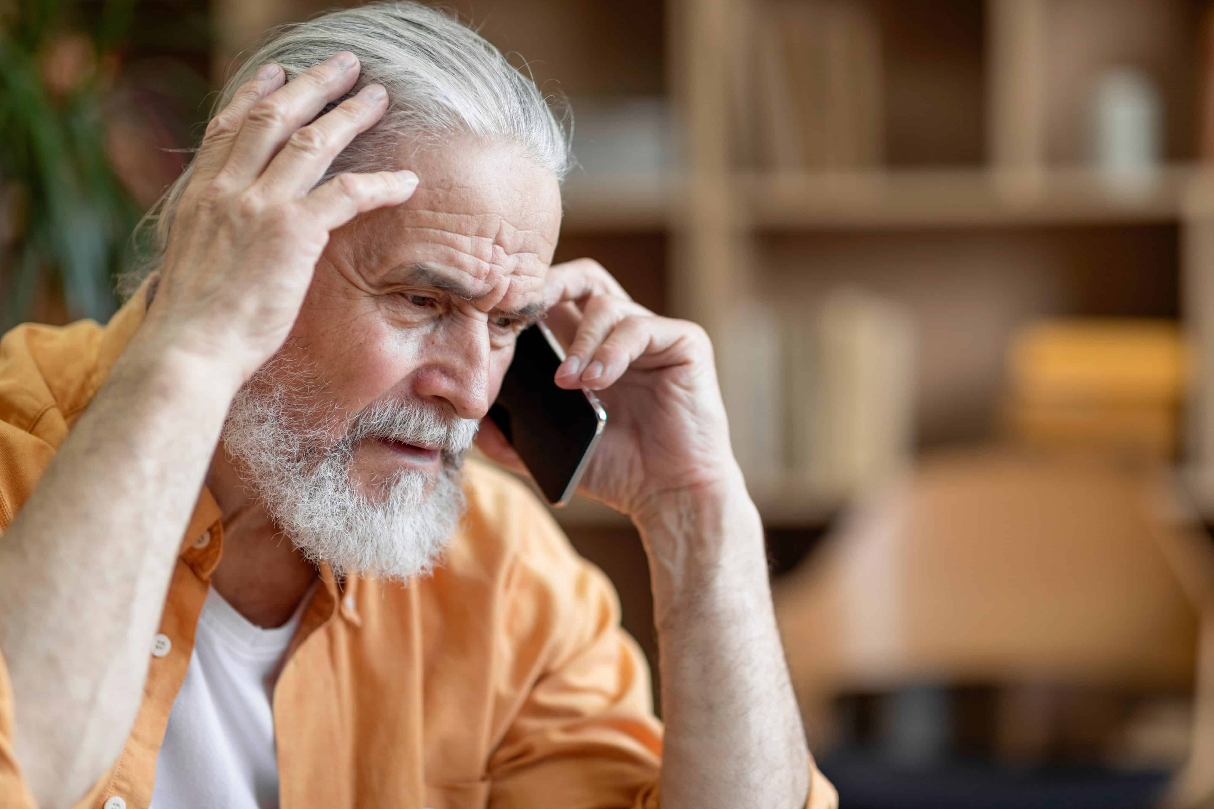 Unhappy,Senior,Man,Having,Phone,Conversation,With,Someone,,Touching,His