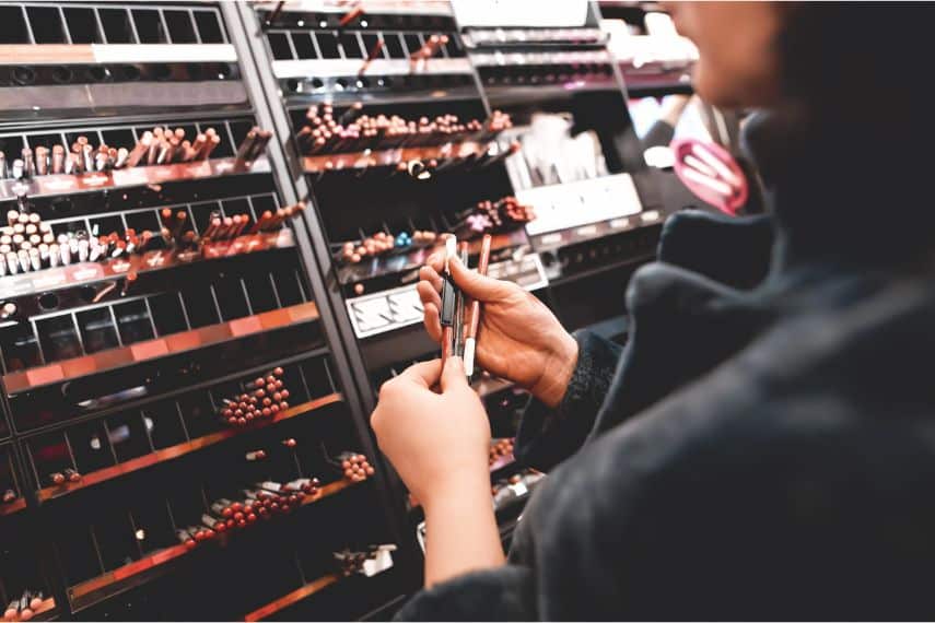 girl choosing make up at store or cosmetics