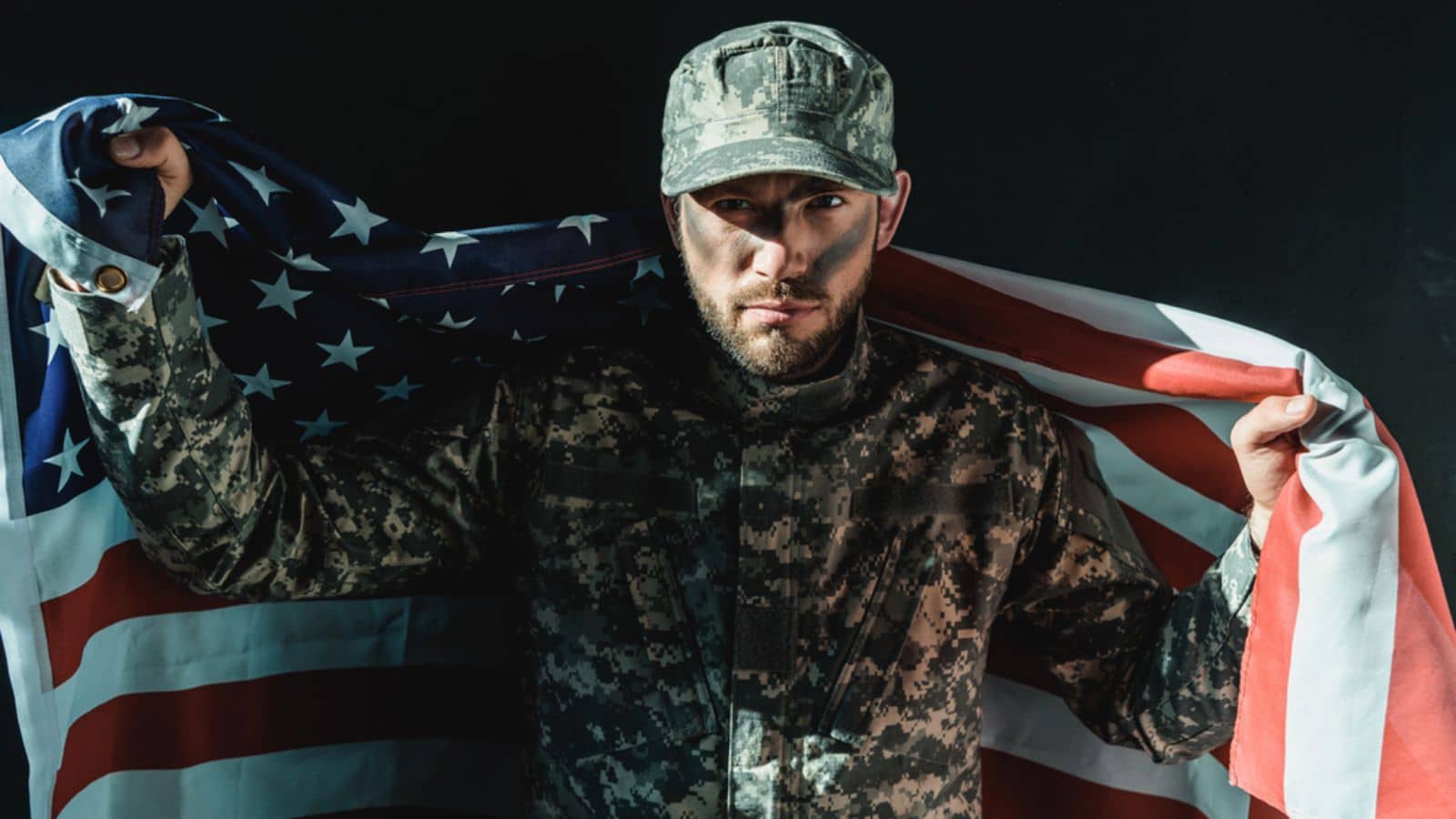Military soldier holding U.S flag