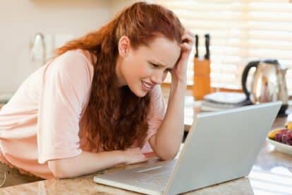 confused woman in kitchen on computer laptop. wavebreakmediamicro via 123rf