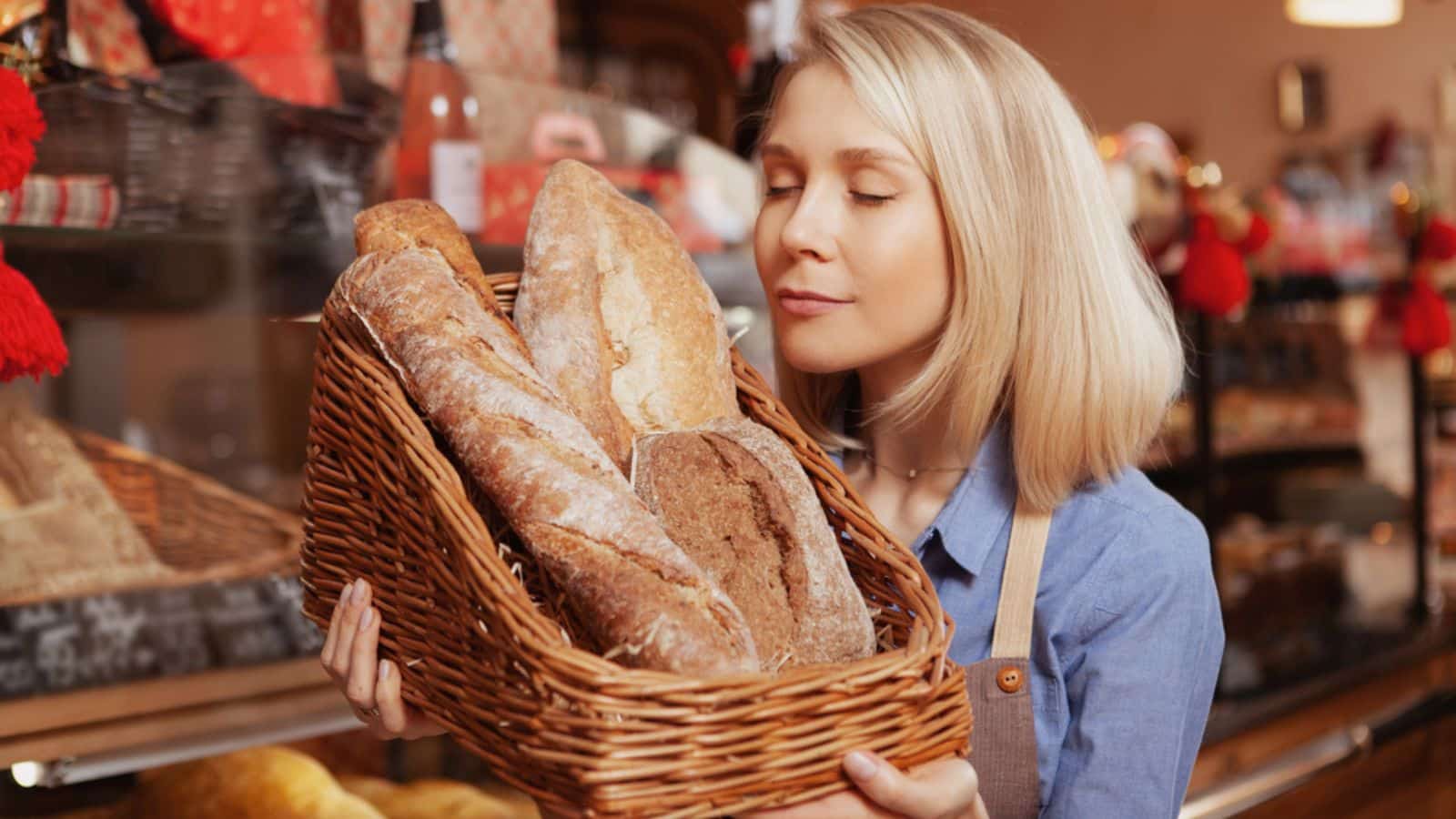 Beautiful female baker smelling fresh bread