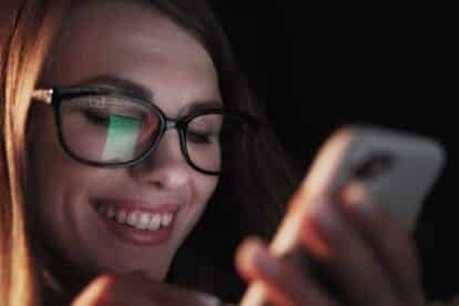 Lady using phone on bed at night
