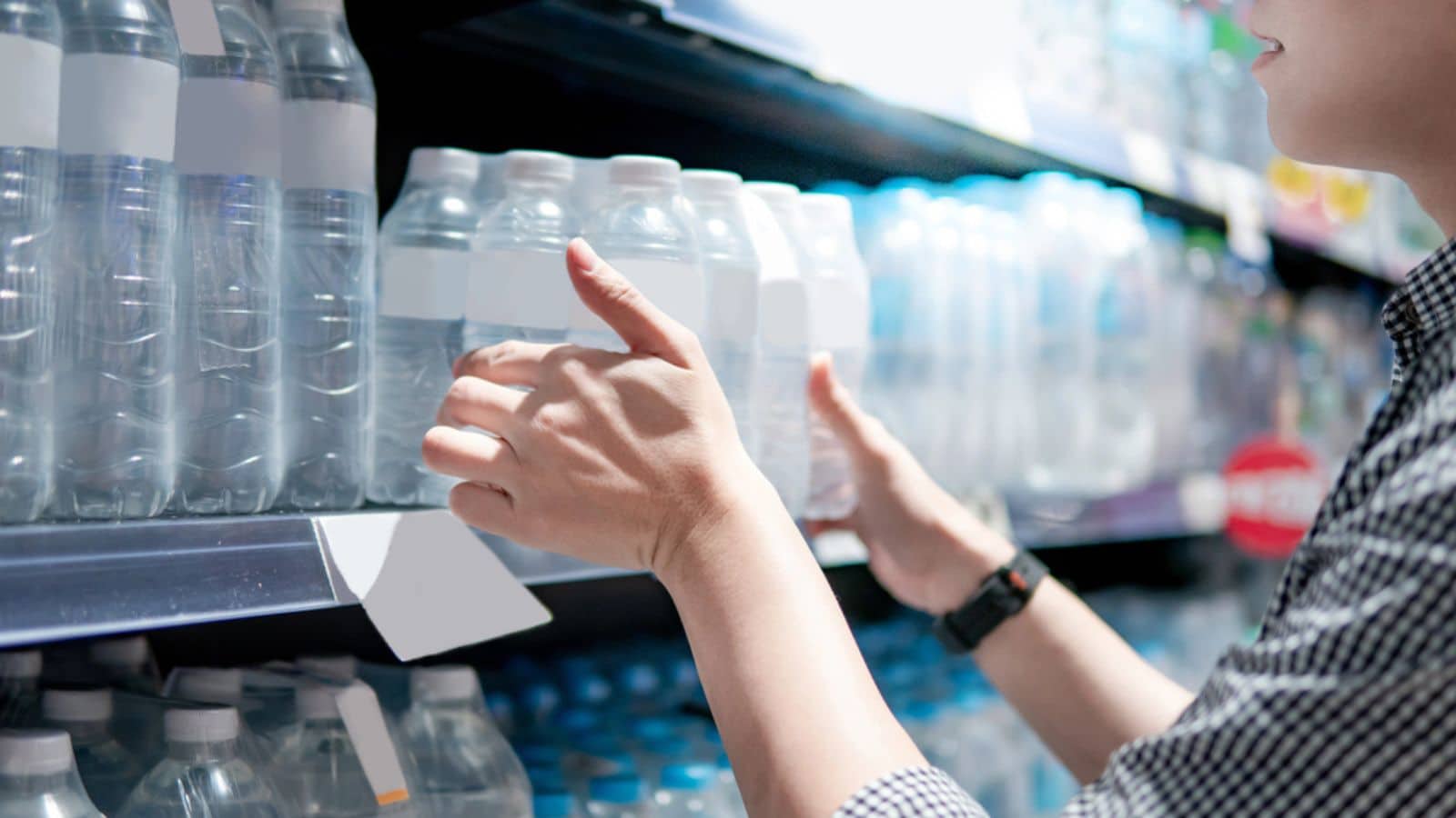 Man buying a pack of bottled water in grocery store