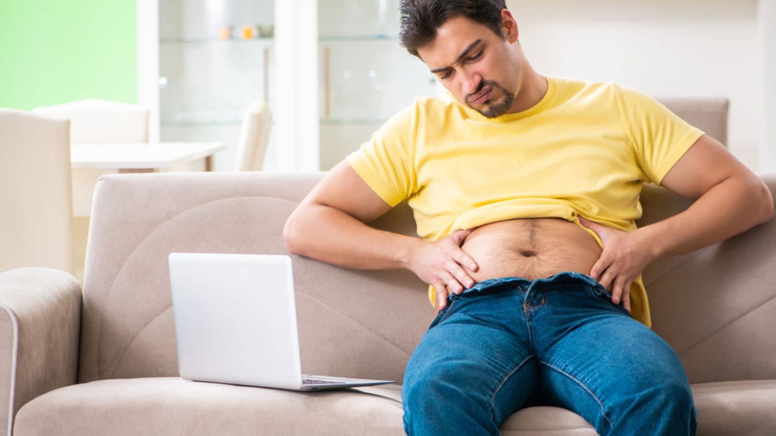 Sad fat man holding and looking at his belly