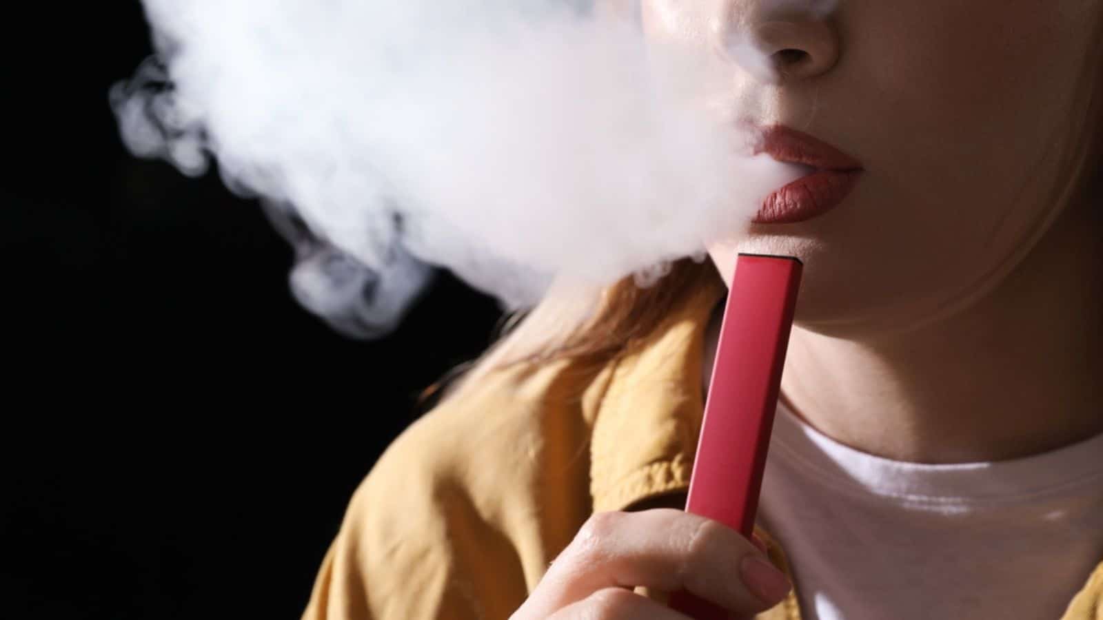 Young woman using electronic cigarette