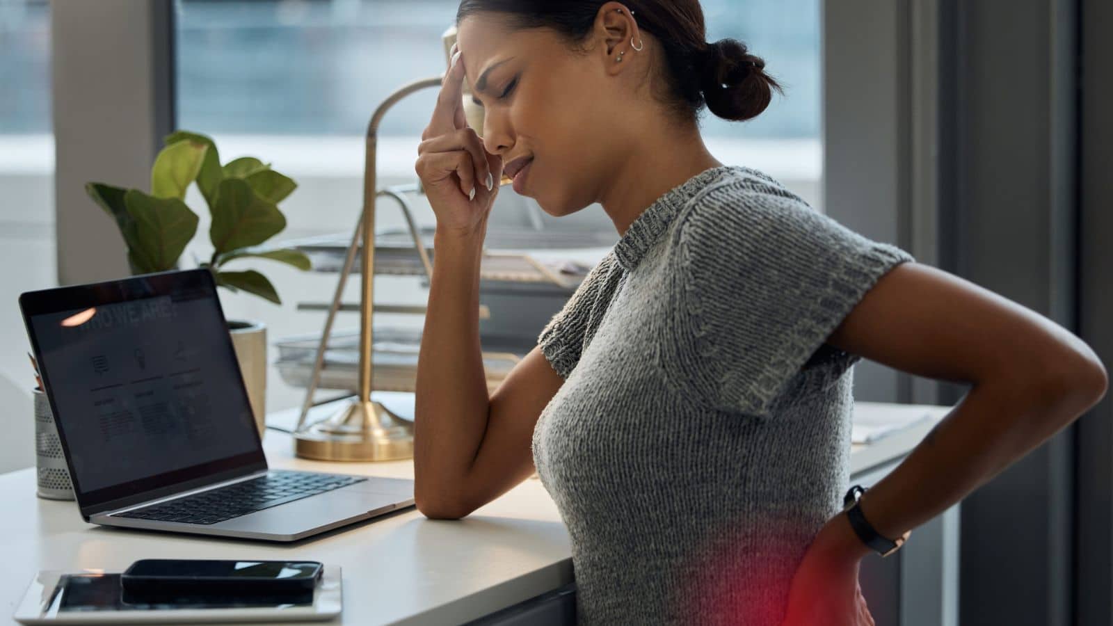 young businesswoman experiencing a headache and back pain