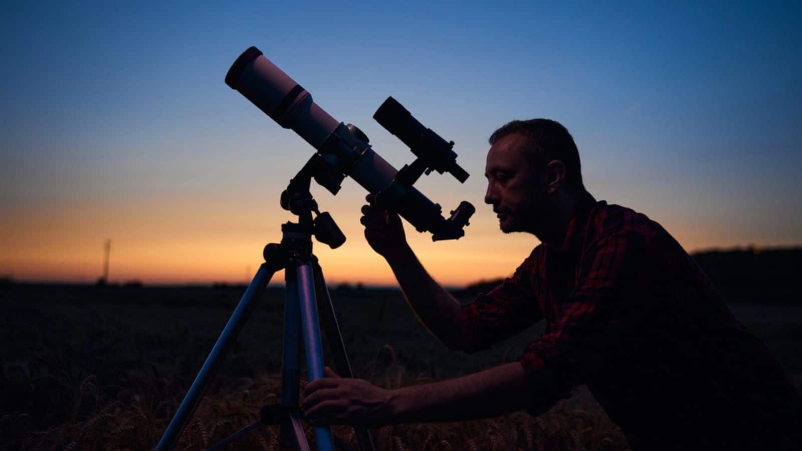 Astronomer looking at night sky with a telescope