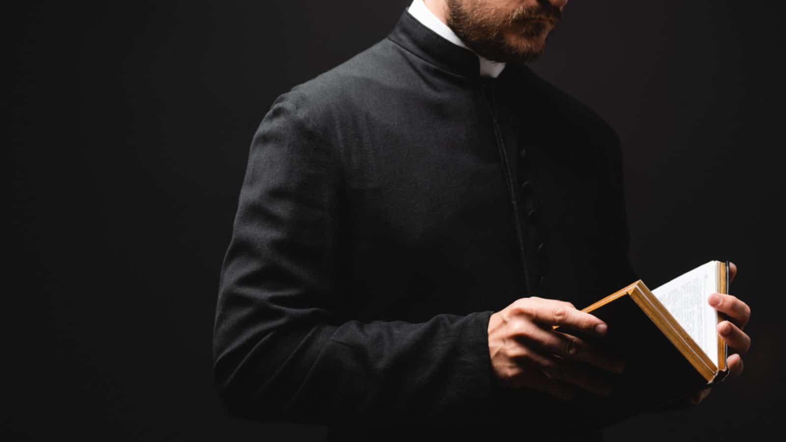 Partial view of bearded pastor holding holy bible