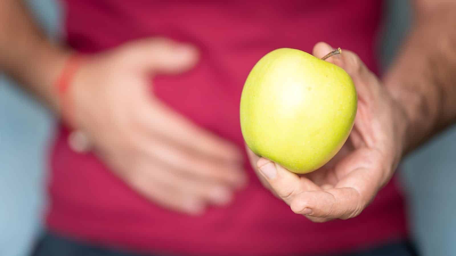 man with stomache ache holding apple. diy13 via 123rf