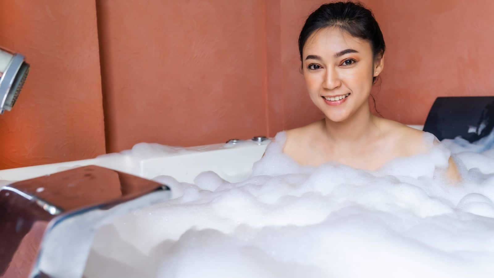 young woman relaxing and takes bubble bath